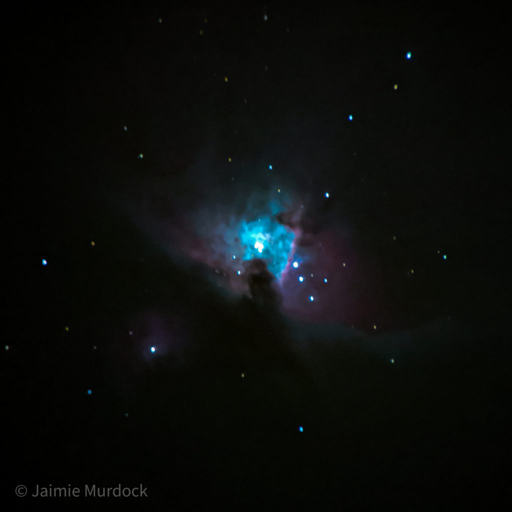 Photograph of the Orion Nebula, taken with a cell phone mounted to the eyepiece, 8 second exposure.